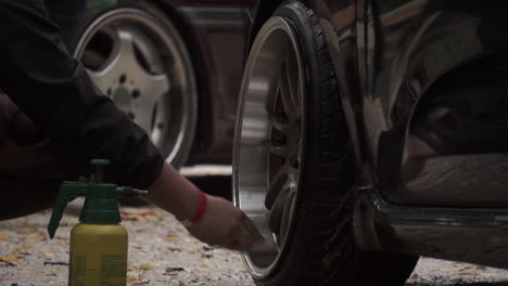 person cleaning car wheels