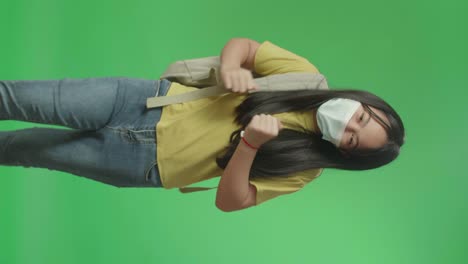 asian girl student wearing mask and running to school on green screen chroma key