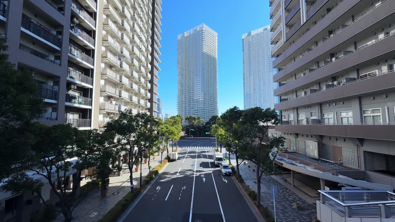 A modern cityscape of Harumi, Tokyo, showing tall buildings and a wide street
