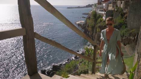 sexy elegant woman in cover up dress walking up stairs after day at beach