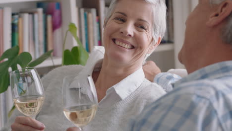 happy old couple drinking wine relaxing on sofa at home making toast celebrating anniversary enjoying romantic relationship on comfortable retirement 4k footage