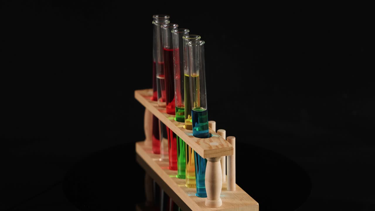 tubos de ensayo con líquidos coloreados en soporte de madera