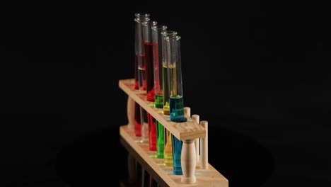 test tubes with colored liquids in wooden holder