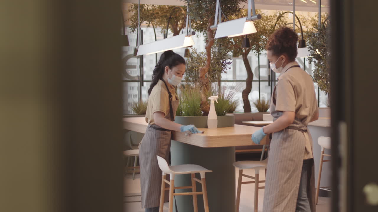Workers Cleaning in Plant-filled Restaurant
