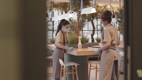 workers cleaning in plant-filled restaurant