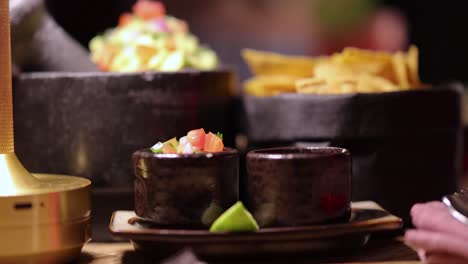 close-up of vibrant mexican dishes with chips and salsa in a warmly lit bangkok restaurant setting
