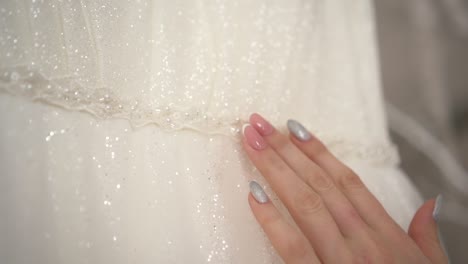 the bride strokes the wedding dress with her hand 02