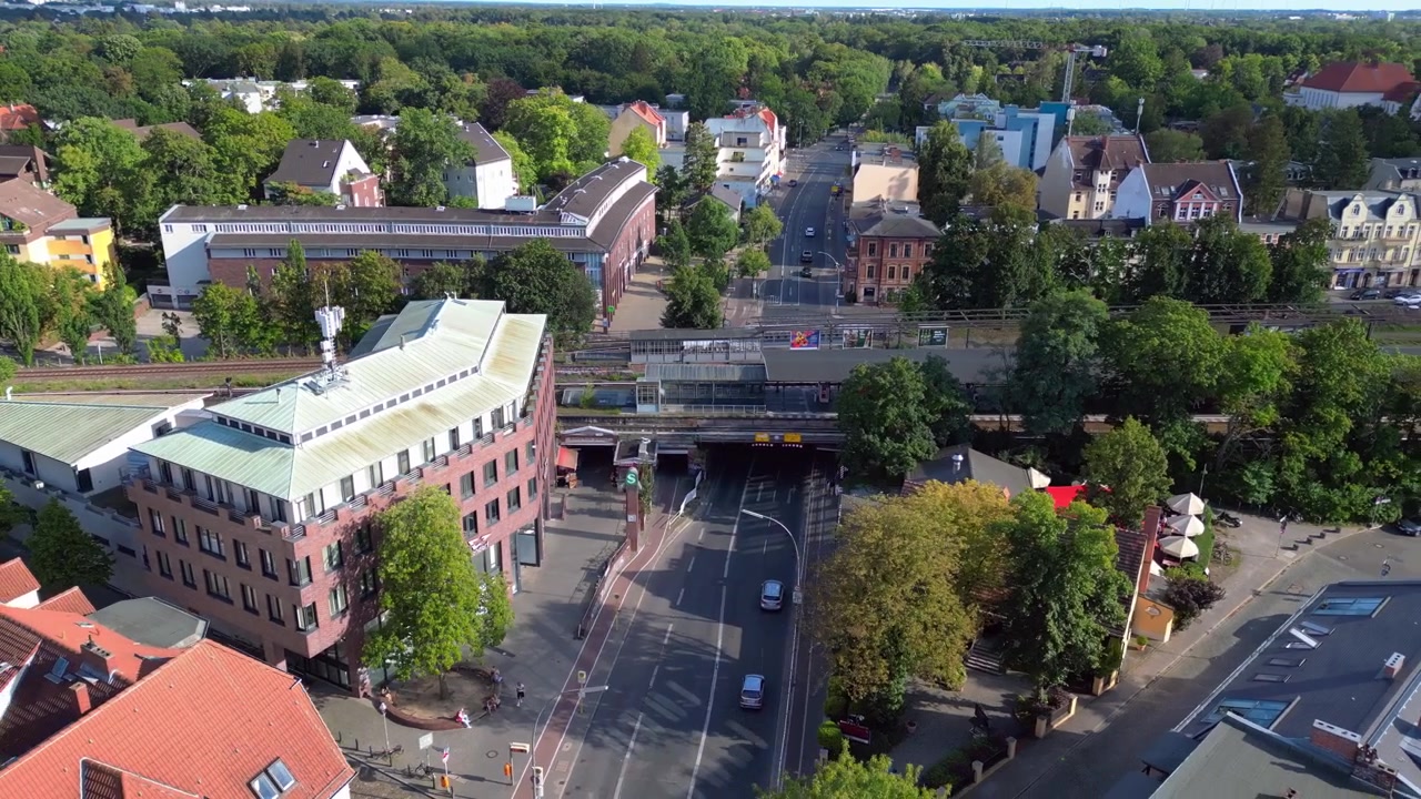 Utrolig luftfoto, panoramaflyvning med drone over Zehlendorf, Berlin, der viser bygninger og S-togstation på en solrig sommerdag.
