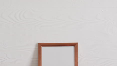 marco de madera con espacio de copia sobre fondo blanco y pared blanca