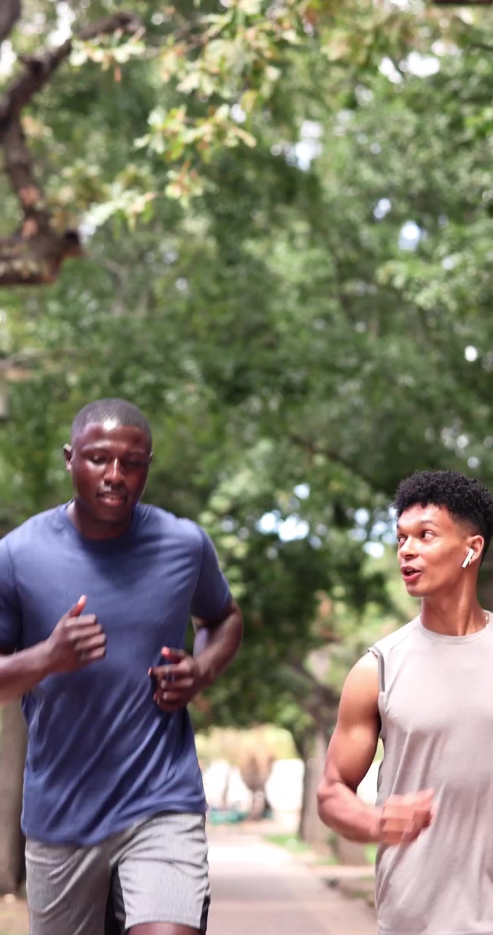 Due giovani uomini che fanno jogging insieme in un parco