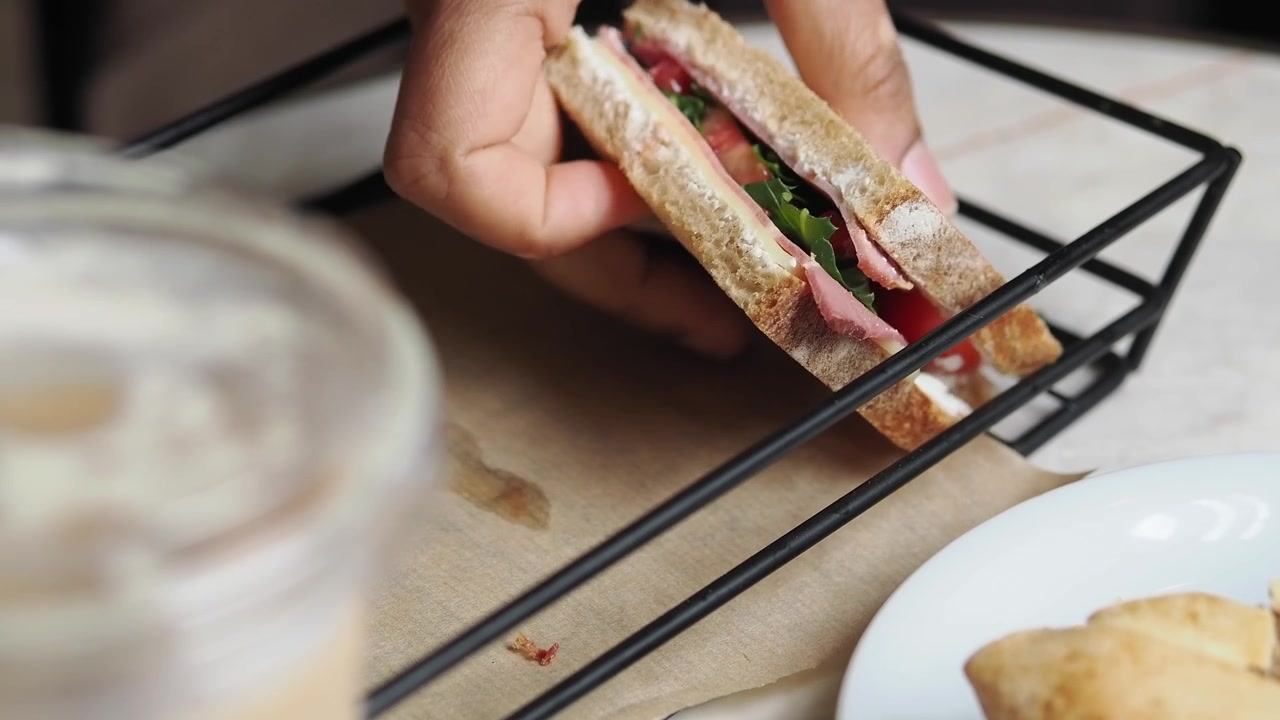 Prendere un panino fresco da gastronomia da un cestino di metallo.