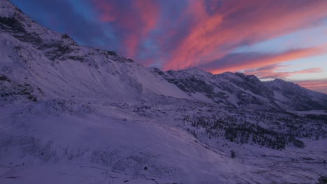 Aerial-View-Of-Beautiful-snow-covered-mountains-and-Dramatic-Pink-Clouds-Overhead