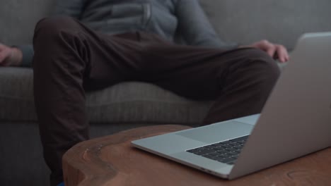 man trying to type on laptop but too lazy and barely makes it