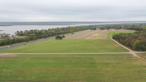 Push-in-aerial-shot-over-the-grassy-fields-of-the-country-side-with-the-Illinois-river-in-the-distance