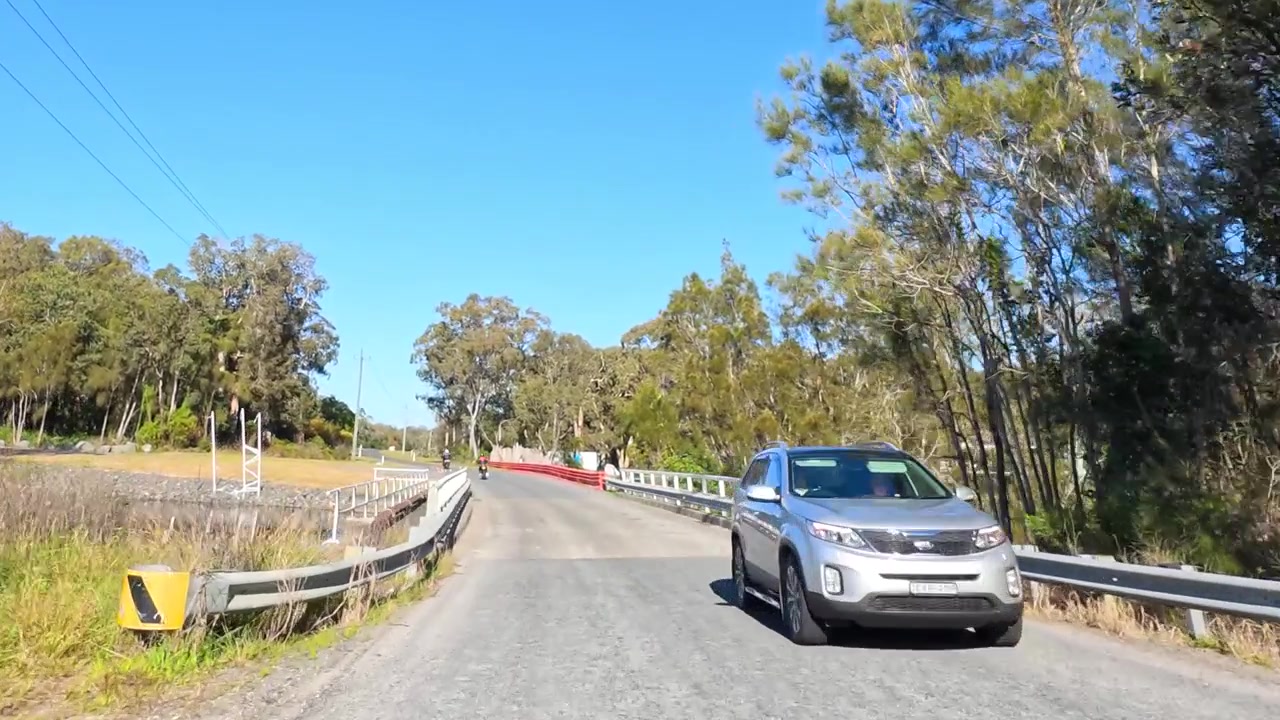 Ripresa soggettiva di veicoli e motociclette che viaggiano su una strada di campagna australiana assolata