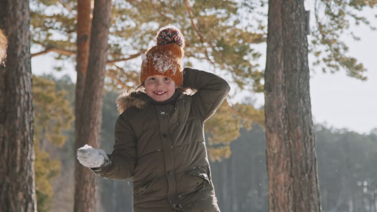 Ritratto di bambina felice che lancia la neve