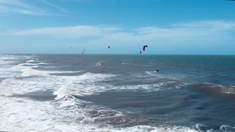 Gruppe-Von-Kitesurfern,-Die-Im-Welligen-Ozean-Reiten