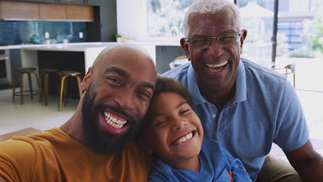 retrato de una familia afroamericana sonriente de varias generaciones sentada en el sofá en casa