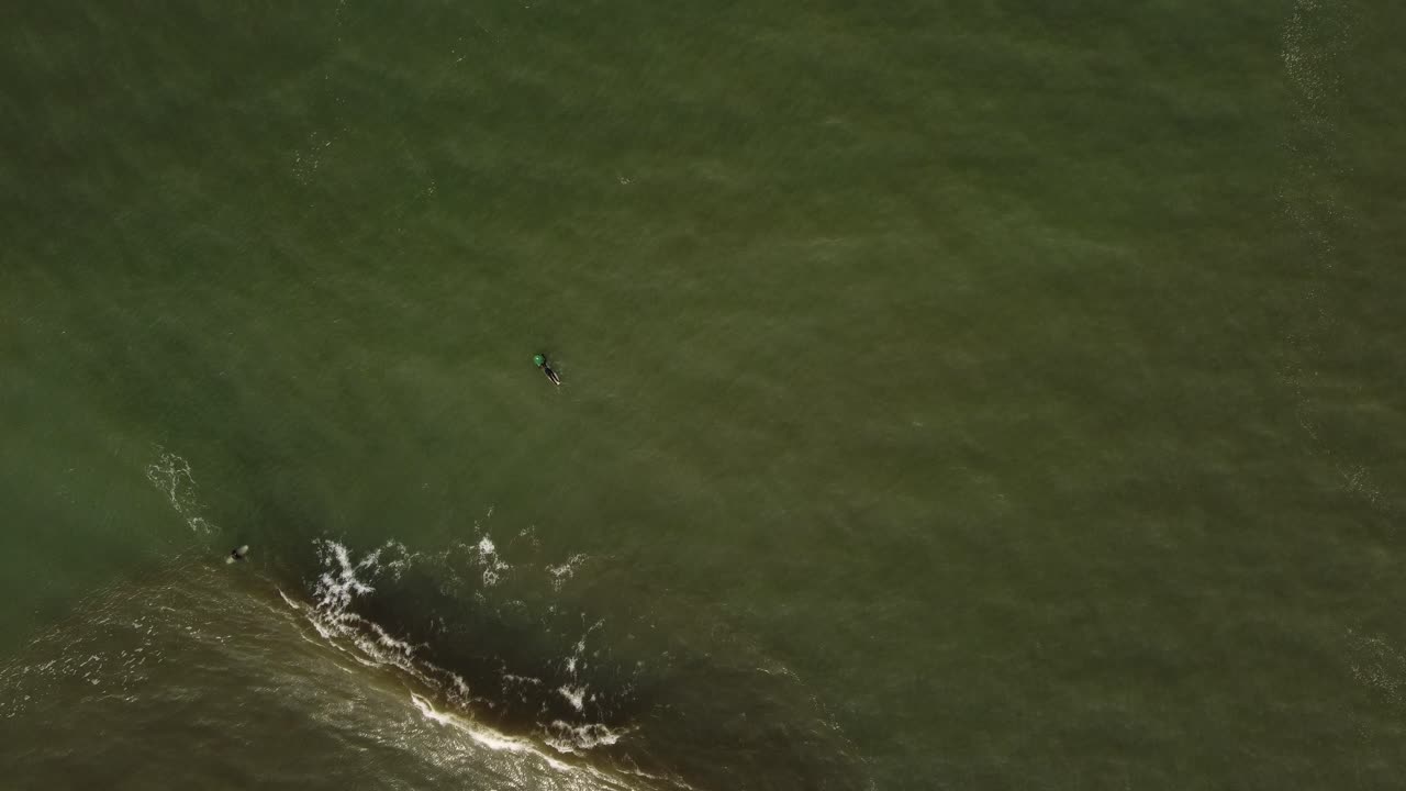 대서양에 들어가는 서퍼의 공중 하향식 샷