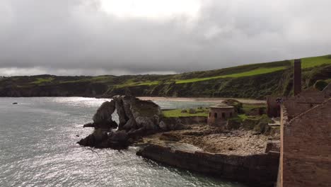 Porth-Wen-aerial-descending-view-down-abandoned-Victorian-industrial-brickwork-factory-remains-on-Anglesey-eroded-coastline