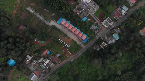 Aerial-bird's-eye-view-of-identical-twin-colorful-buildings-in-a-remote-green-neighborhood-in-India,-wide-shot