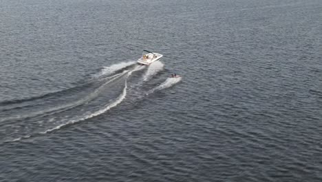 tourist speed boat cruising in blue sea water - aerial drone shot