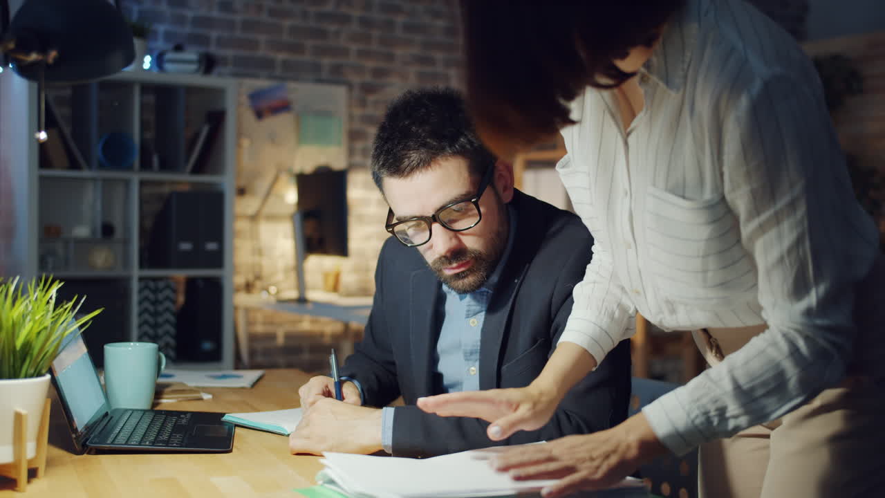 Colegas de trabalho trabalhando até tarde da noite no escritório