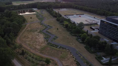 increíble toma de un avión no tripulado de un parque con un camino en zigzag en el medio entre los edificios y la naturaleza