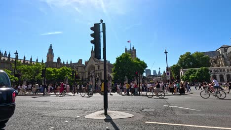 cyclists ride past westminster on a sunny day