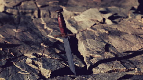 excalibur sword in rocky stone at sunset