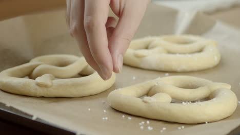 closeup shot of a hand placing salt on a frozen pretzel