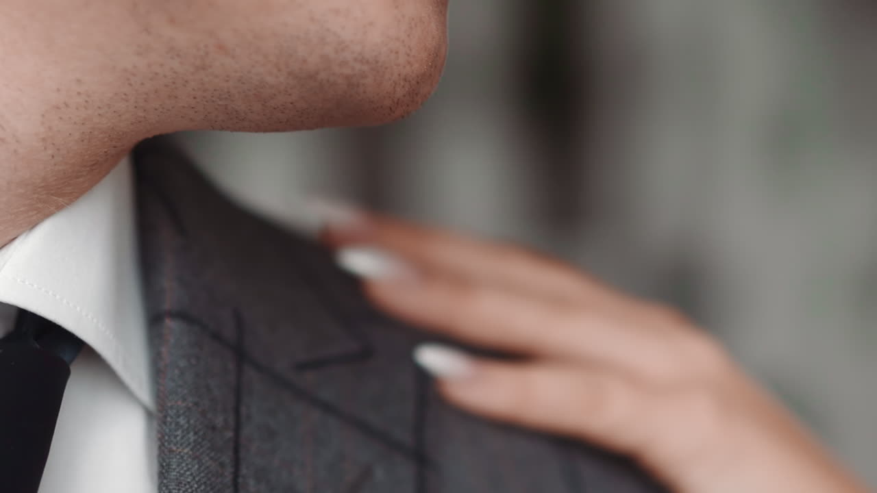 여자가 재 ⁇ 을 입은 남자의 어깨를 만지고 남자는 머리를 뒤로 돌립니다.