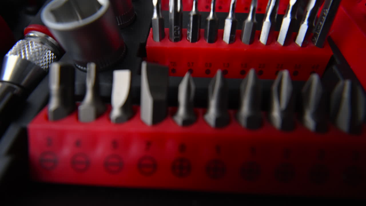 Primo piano di un kit di attrezzi professionale con punte per cacciavite e bussole ben organizzati.