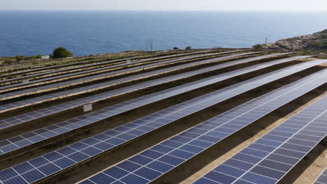 aerial view over a solar panel field, toward the mediterranean sea in sunny malta