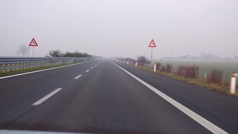 empty and straight highway and landscape with fog - slow motion