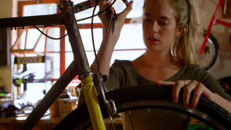 mujer reparando el ciclo en el taller 4k
