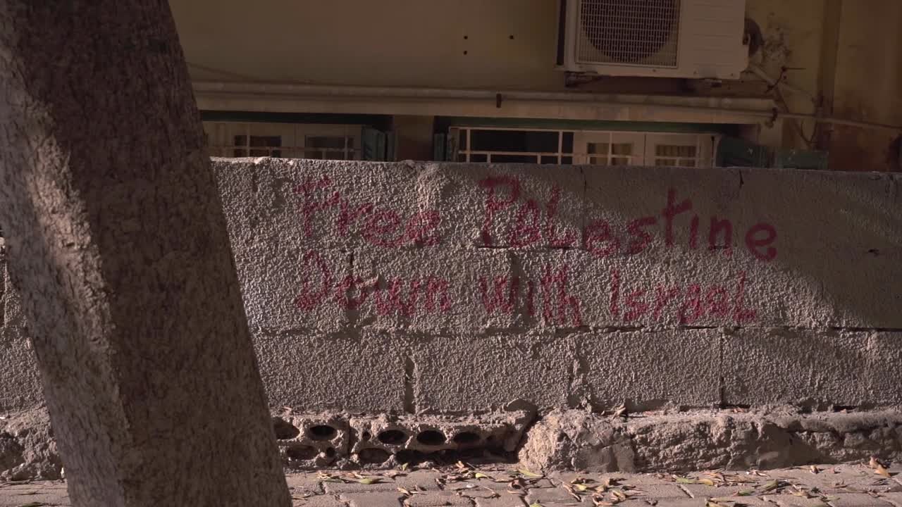inscripción política en una vieja pared de piedra en un distrito residencial