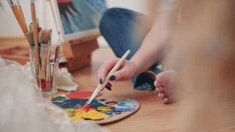 an unrecognizable woman mixing colors on a painter's palette 1