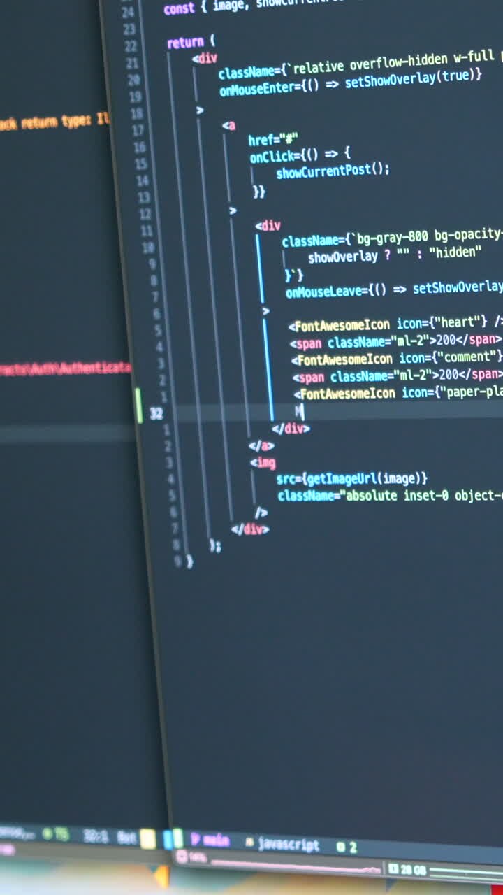 Close-up of coding on dual screens featuring JavaScript. Bright, focused lighting enhances the text details. Perfect for vertical video in mobile and social media