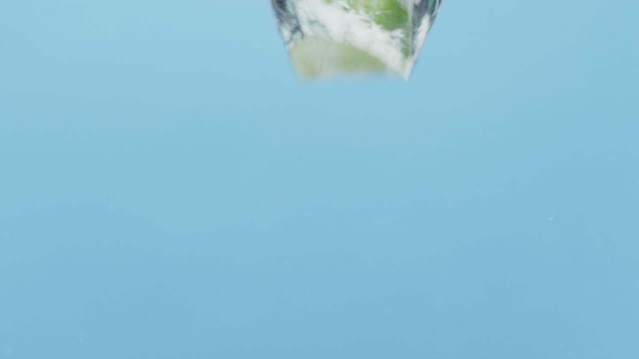 블루 배경에 복사 공간과 함께 물에 떨어지는 열매와 과일의 비디오