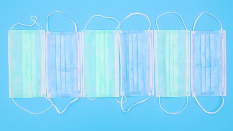 blue and green medical masks for prevention covid-19 appear on blue theme. stop motion