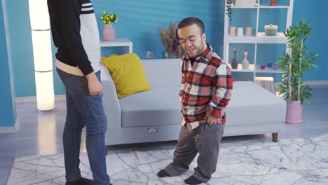 Young-man-with-dwarfism-chatting-and-greeting-with-his-close-male-friend-at-home.