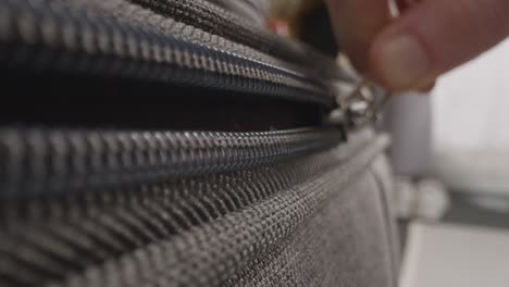 close up of person at home unzipping and unpacking suitcase on summer holiday 1