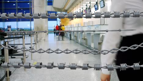 barbed wires against air hostess walking in airport