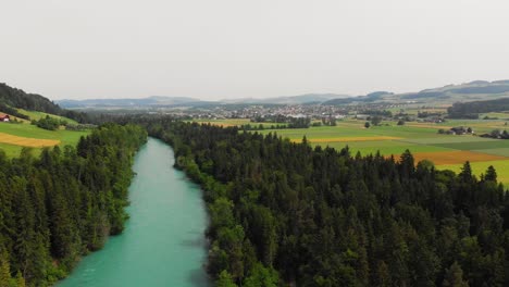 Aerial-of-a-river-surrounded-by-forest-and-hills