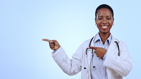 Pointing,-happy-and-face-of-woman-doctor-in-studio