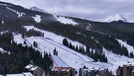 snow making half pipe big air jump ski snowboard gondola ski lift aerial drone cinematic copper mountain base colorado winter december christmas ski runs trails landscape rocky mountains circle right