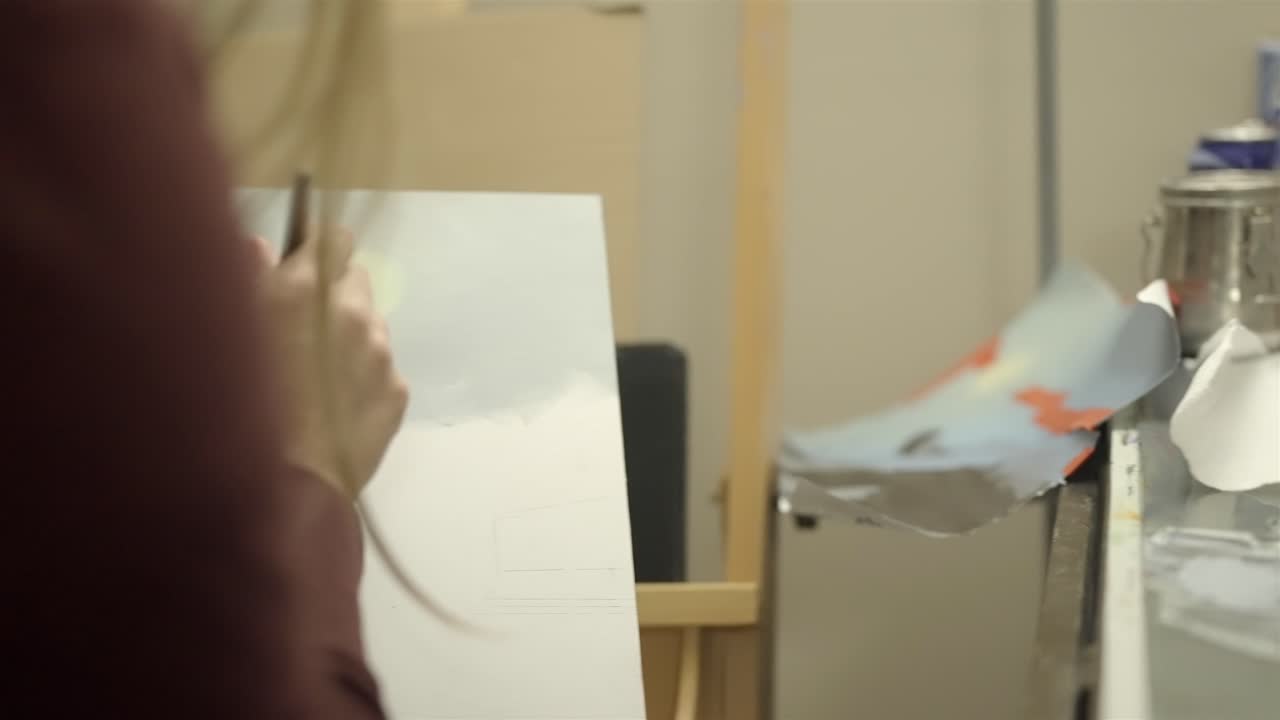 Primo piano delle pennellate di un'artista su tela, scatto del processo creativo.