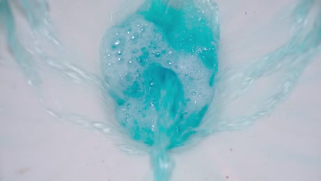 primer plano del inodoro con un producto de limpieza azul