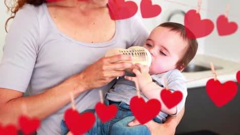 Animation-of-falling-hearts-over-happy-caucasian-mother-with-baby